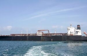 ‘Ties Between India, Iran Very Strong’: Tehran’s Envoy After Tanker Attacked Near Hormuz A woman talks on a phone while standing amid a damaged residential neighbourhood hit by a strike amid the US-Israeli conflict. (IMAGE: REUTERS)